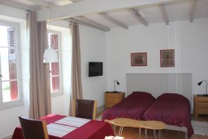 een slaapkamer met een bed en een tafel en stoelen bij Castel Rouge in Luzech