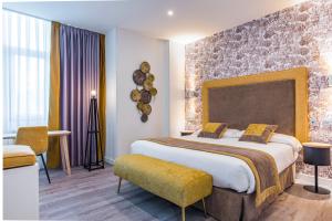 Una habitación de hotel con una cama grande y una silla. en Hotel Santa Cruz, en Cangas de Onís 37 fotos más