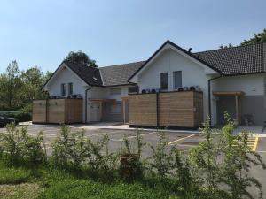 a house with two garages with wooden fences at Apartment Green Paradise in Moravske-Toplice