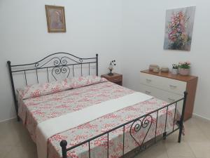 una camera da letto con un letto con copriletto floreale di Casa vacanza Corallo a Castellammare del Golfo