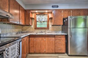 eine Küche mit Holzschränken und einem Kühlschrank aus Edelstahl in der Unterkunft Cozy Family Home with Kayaks, Dock and Fire Pit! in Springfield