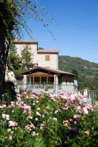 una casa con una valla blanca y flores rosas en Agriturismo Cornali, en Fabbriche di Vallico