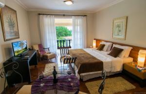 1 dormitorio con 1 cama y balcón en Garden Hill Hotel e Golfe en São João del Rei