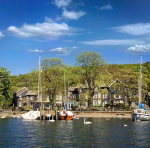 boats are docked in the water at The Waterhead Inn in Ambleside