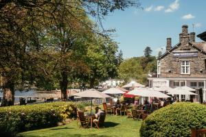 a person sitting at a table in front of a building at The Waterhead Inn, Ambleside- The Inn Collection Group in Ambleside