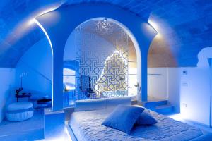 a blue room with a bed with a large window at Antica Torre di Iuso in Matera