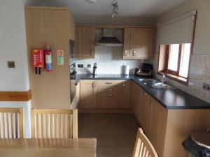 a small kitchen with wooden cabinets and a table at Macdonald Spey Valley Resort in Aviemore