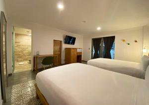 een hotelkamer met 2 bedden en een bureau bij Hotel MX condesa in Mexico-Stad
