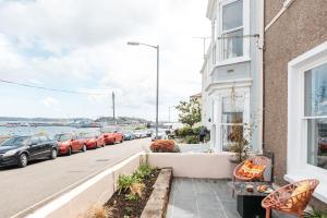 a row of cars parked on a street next to a building at Stunning views over the beautiful Falmouth Harbour in Falmouth