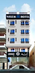 een hotel met een bord aan de zijkant van een gebouw bij NASEEM HOTEL in Muscat