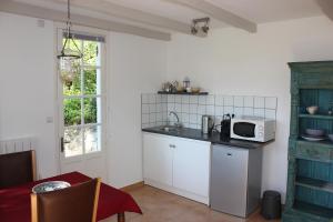 a kitchen with a sink and a microwave on a counter at Castel Rouge in Luzech +22 photos