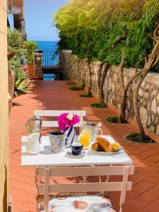 - Mesa con desayuno de zumo de naranja y cruasanes en L'Angolo di Felicia, en Nerano