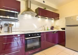a kitchen with purple cabinets and stainless steel appliances at Karpacz wczasy in Karpacz