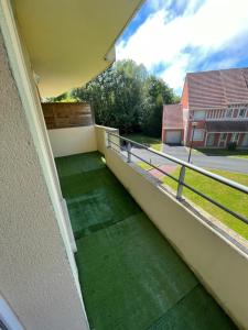 a balcony with green flooring on a house at F3 proche Deauville Piscine in Touques