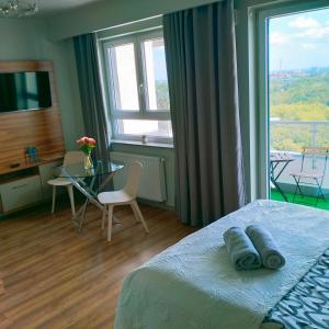 a bedroom with a bed and a table and a window at ParkCity Katowice in Katowice
