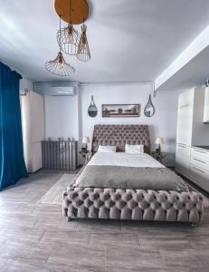 a bedroom with a large bed and a blue curtain at Mamaia Luxury Studio Apartment T in Mamaia +15 photos