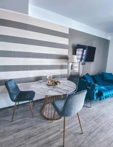 a living room with a table and chairs and a couch at Mamaia Luxury Studio Apartment T in Mamaia