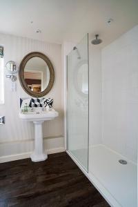 a bathroom with a sink and a shower and a mirror at The Manor House Hotel in Moreton in Marsh
