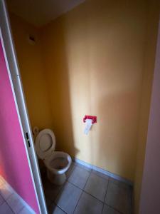 a bathroom with a toilet and a paper dispenser on the wall at F3 proche Deauville Piscine in Touques +6 photos
