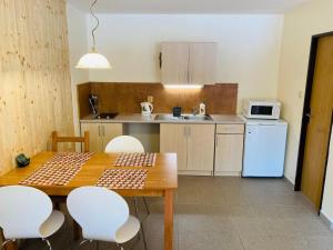 a kitchen with a wooden table and white appliances at Studia Pod Lysou in Rokytnice nad Jizerou