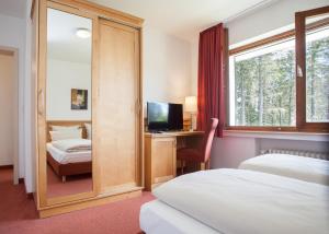 a hotel room with a bed and a desk with a computer at Der schöne Asten - Resort Winterberg in Winterberg