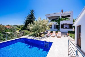 a villa with a swimming pool and a house at Holiday Home Malinina in Mali Iž