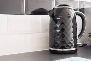 a black and silver tea kettle on a kitchen counter at Mayberry Lodge in Selsey