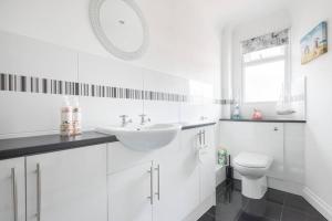 a white bathroom with a sink and a toilet at Mayberry Lodge in Selsey +17 photos