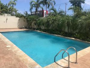 a swimming pool at a house with a blue pool at Furnished Apartment - Residencial Olas - Gated Community - 24 hr Security in San Felipe de Puerto Plata