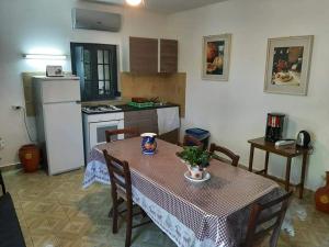 eine Küche mit einem Tisch mit Stühlen und einem Kühlschrank in der Unterkunft Carrubo - Giardino in città in Catania