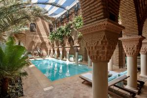 a large swimming pool in a building with a building at La Sultana Marrakech in Marrakesh