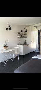 a white kitchen with a sink and a table at Hideaway Engvej in Guldborg