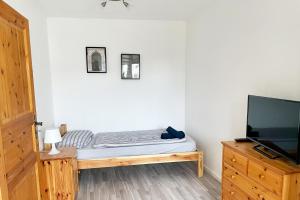 1 dormitorio con 1 cama y TV de pantalla plana en Schöne 3 Zimmerwohnung in Düren, en Düren - Eifel