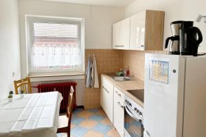 a kitchen with a white refrigerator and a table at Schöne 3 Zimmerwohnung in Düren in Düren - Eifel