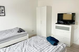 a bedroom with a bed and a flat screen tv at Schöne 3 Zimmerwohnung in Düren in Düren - Eifel