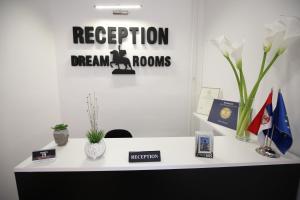 an office desk with a sign that reads reception dream rooms at Apartments & Dream Rooms in Niš