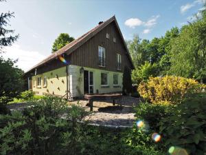 a house with a bench in front of it at Pod Lipami in Zawady