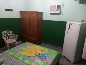 a room with a table and a refrigerator at Hotel Marabá in Jundiaí