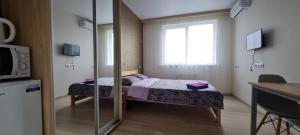 una piccola camera con letto e finestra di Apartments Swan Lake a Kiev