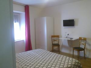 sypialnia z łóżkiem i biurkiem z 2 krzesłami w obiekcie B&B The Secret Place w mieście Cavedago