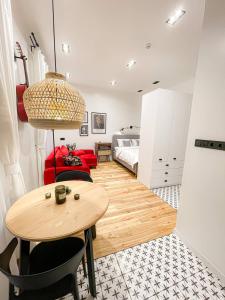 a room with a table and a red couch and a bed at Poetry Apartments in the city center in Kharkiv