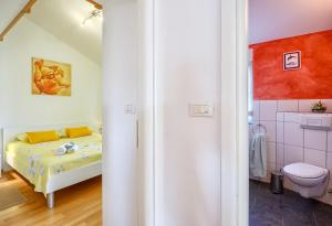 a small bedroom with a bed and a bathroom at Apartman Maksim in Banjole