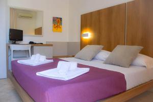 a large bed with two towels on top of it at Hotel Sikania in San Vito lo Capo