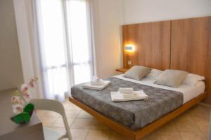 a bedroom with a bed with two towels on it at Hotel Sikania in San Vito lo Capo
