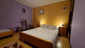 a bedroom with a large bed with white sheets at Apartman Štimac in Crni Lug