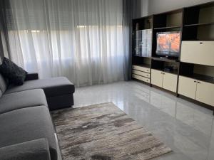 a living room with a couch and a television at Apartmani Ankica in Kampor