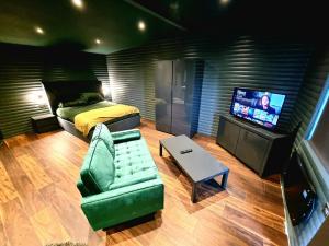 1 dormitorio con cama, sofá y TV en Yaseva Lodge, Stylish Country Retreat for 2, Hot Tub, Exceptional Views!, en Carr