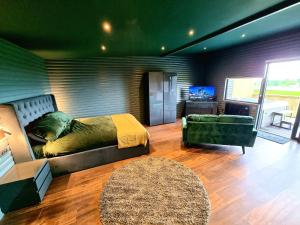 a bedroom with a bed and a couch and a television at Yaseva Lodge, Stylish Country Retreat for 2, Hot Tub, Exceptional Views! in Carr +7 photos
