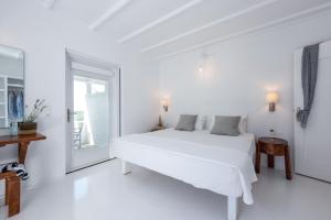 Un dormitorio blanco con una cama blanca y una ventana en Casa Montzo boutique hotel, en Katelios