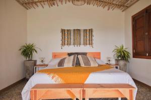 a bedroom with a bed and a window and two plants at Lodge Paraíso Verde in Manizales